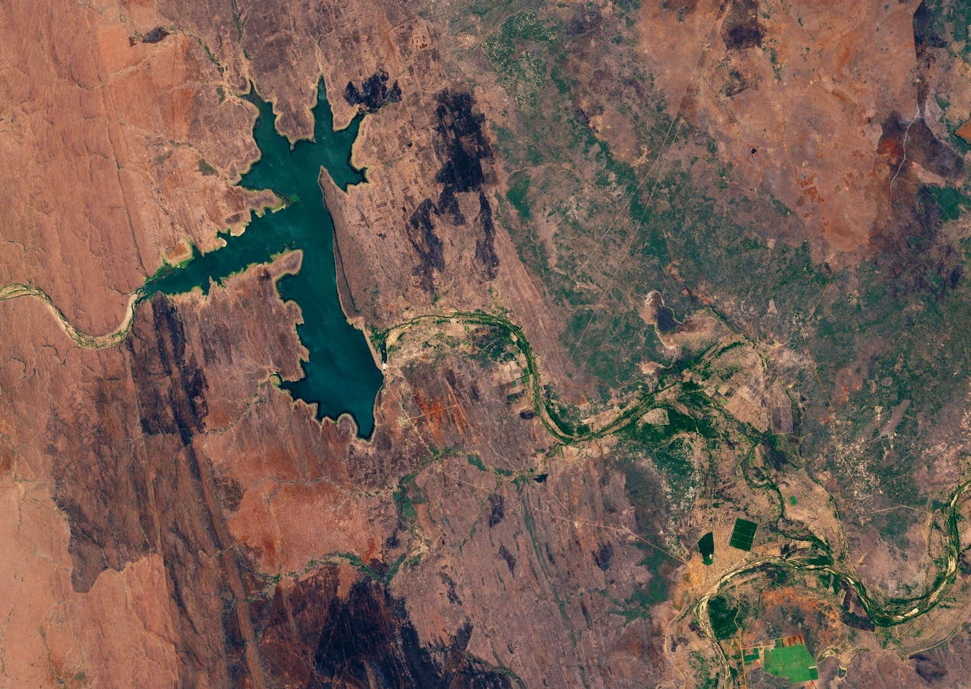 Imagem de satélite da albufeira de Corumana, em tons de verde e castanho