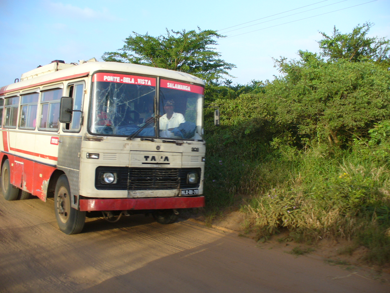 Machimbombo vermelho e branco numa estrada de terra em Salamanga